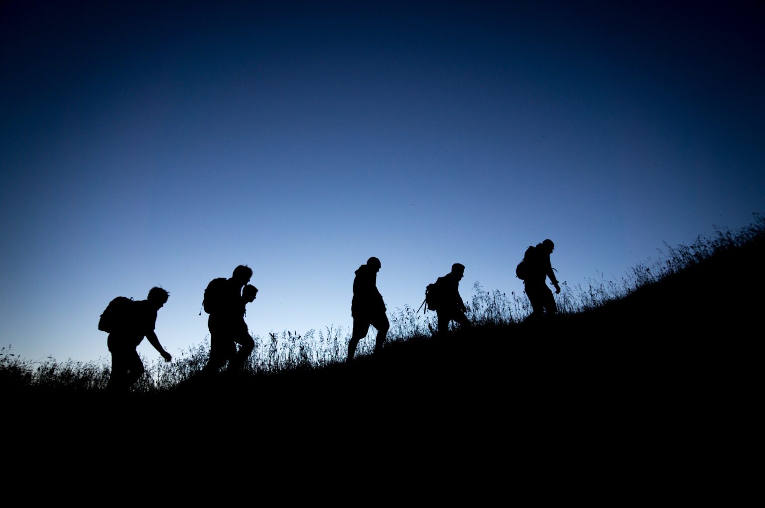 A team of hikers ascend a hill